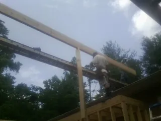 Carpenter setting a ridge beam over a new addition frame — Ice Dam Removal by Roofing Brothers in Festus