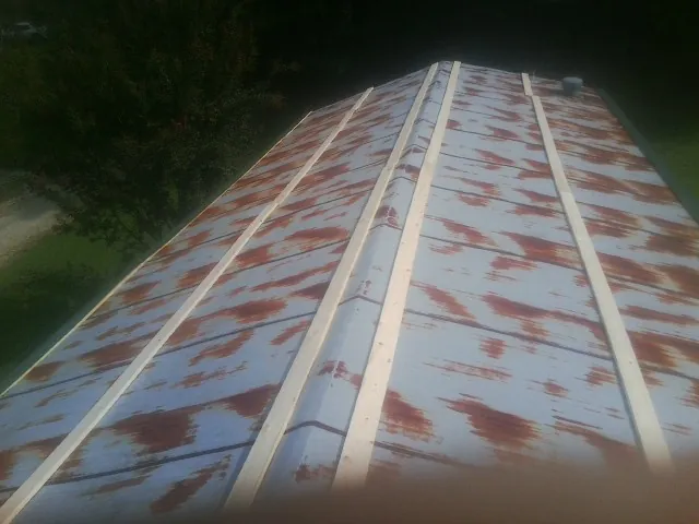 Rusted metal roof panels with new wood purlins before replacement — Storm Damage Roof Repair in Festus by Roofing Brothers
