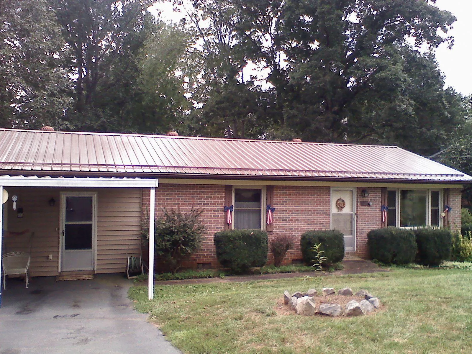 Bronze metal roof and carport on a brick ranch home — Roof Repair work by our crew in Festus