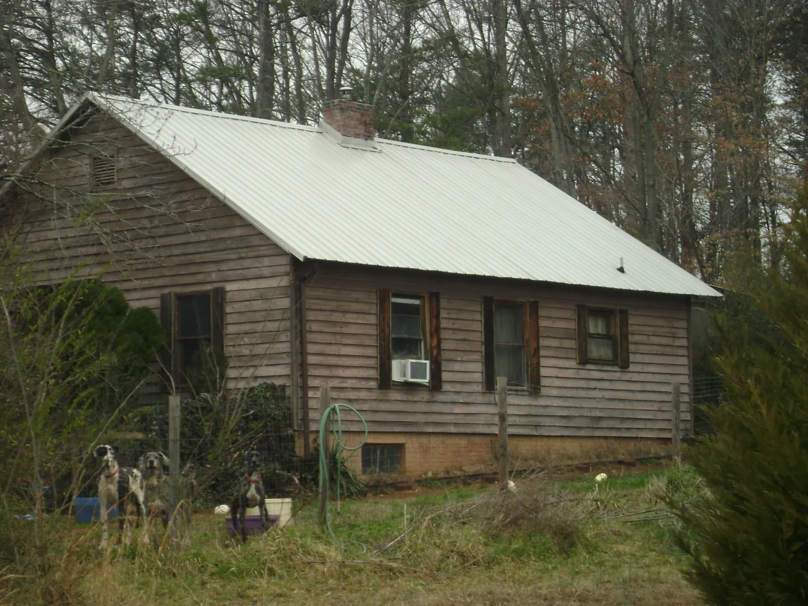 White metal roof on an old wood sided farmhouse, from a Metal Roof Installation job in Festus